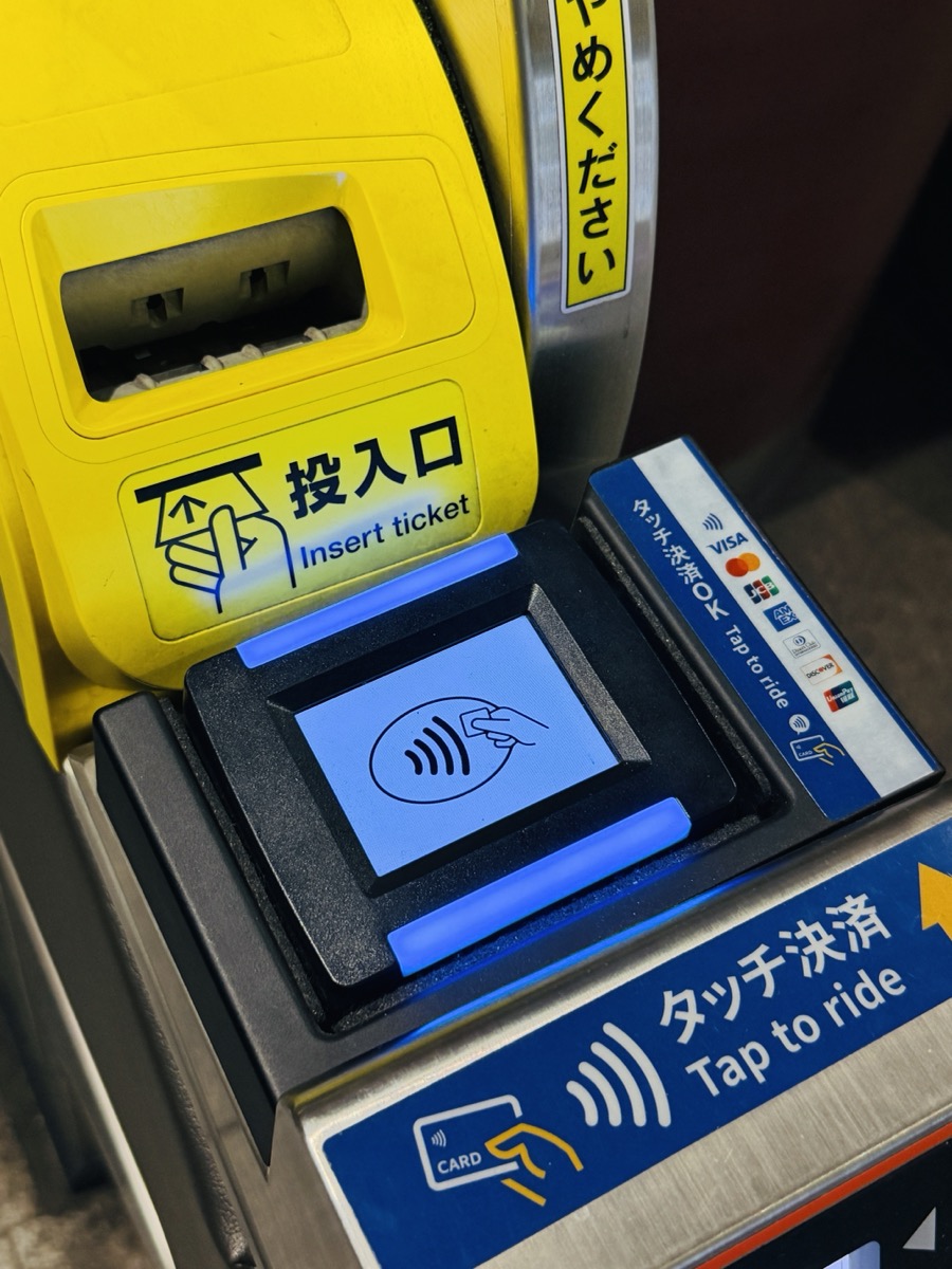 The ticket gate at Otemachi station on the Tokyo Metro, showing three ways to enter: a paper ticket slot, an IC card reader, and a contactless credit card reader with Visa, Mastercard, JCB, American Express, UnionPay, and Discover stickers plus English &lsquo;Tap to ride&rsquo; signage