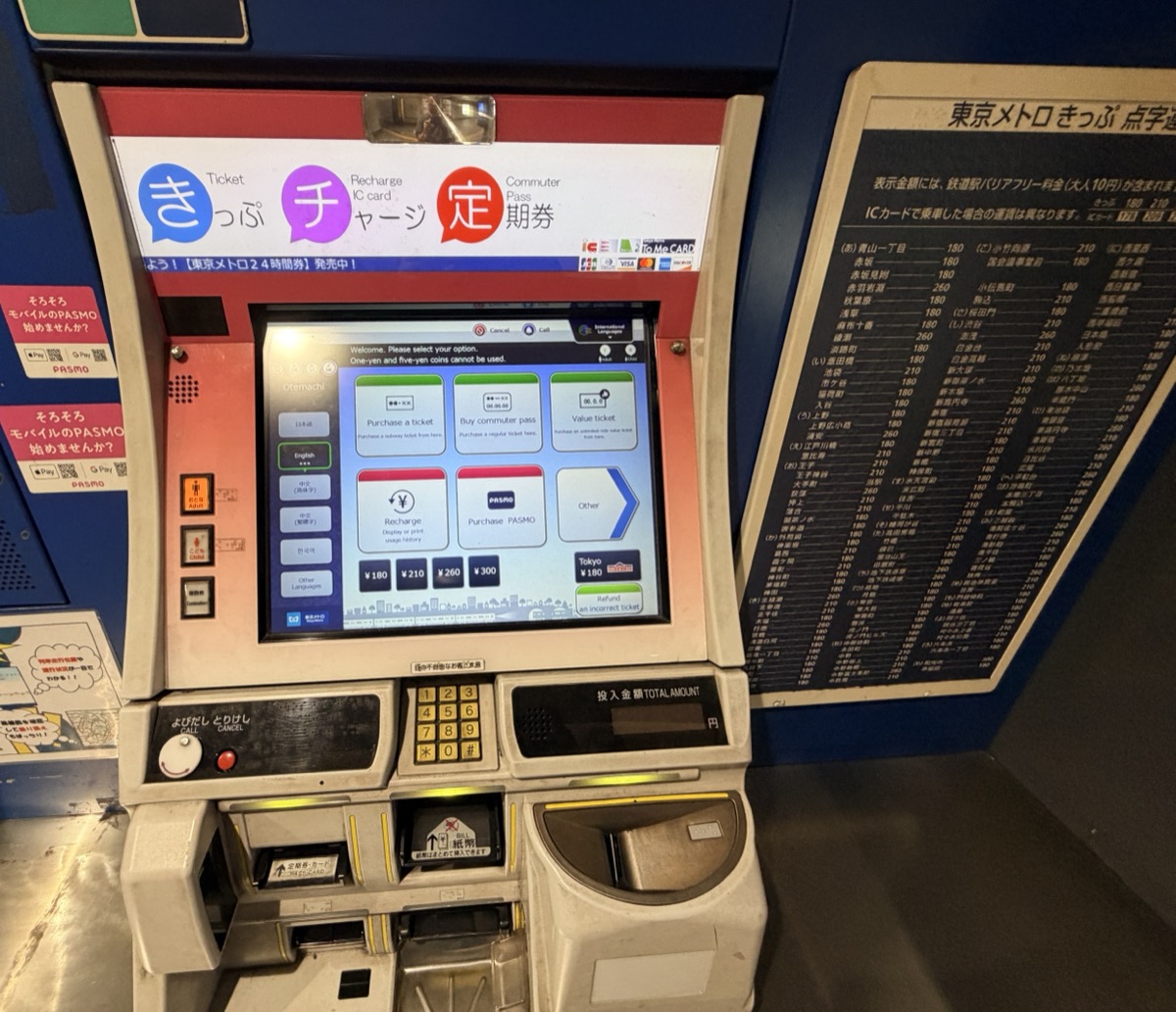 The wider ticket-machine bay at Otemachi station, with PASMO signage on the left panel and a Tokyo Metro 24-hour ticket poster above